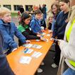 Man sieht einen Biertisch, um den Kinder und Jugendliche stehen. Auf dem Tisch sind Kärtchen mit europäischen Flaggen, Sehenswürdigkeiten und Ländernamen