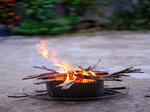 Man sieht ein kleines Lagerfeuer in einem Topf